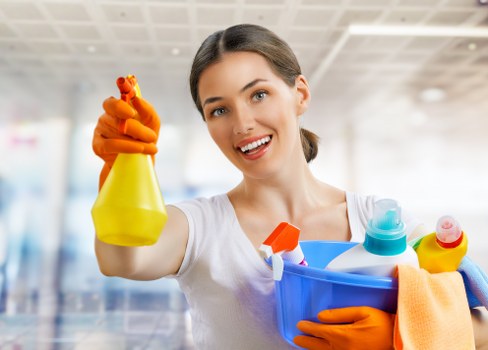 Cleaner in a London home using safe cleaning practices with protective equipment